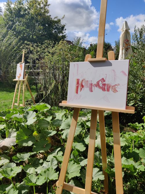 Sur des chevalets, dans un décor très végétal, deux tableaux (calligraphie contemporaines)